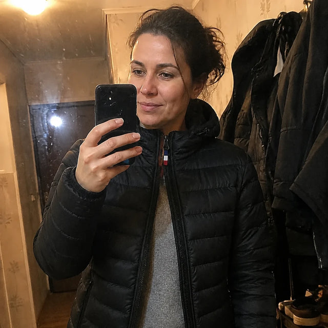 Female customer in the black heated Ridge 21 down jacket, photographed in her hallway